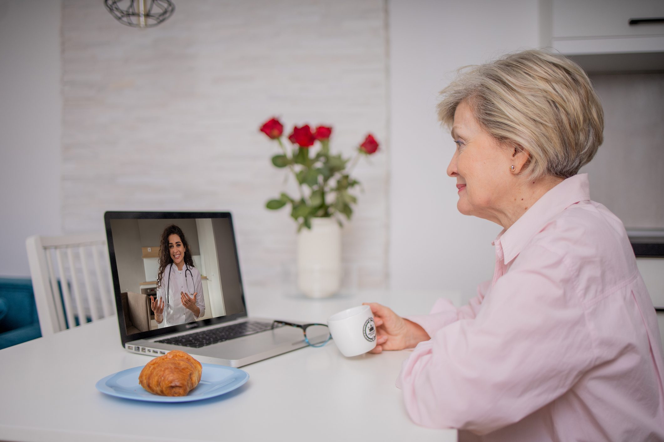 Elderly woman video chatting with doctor online.