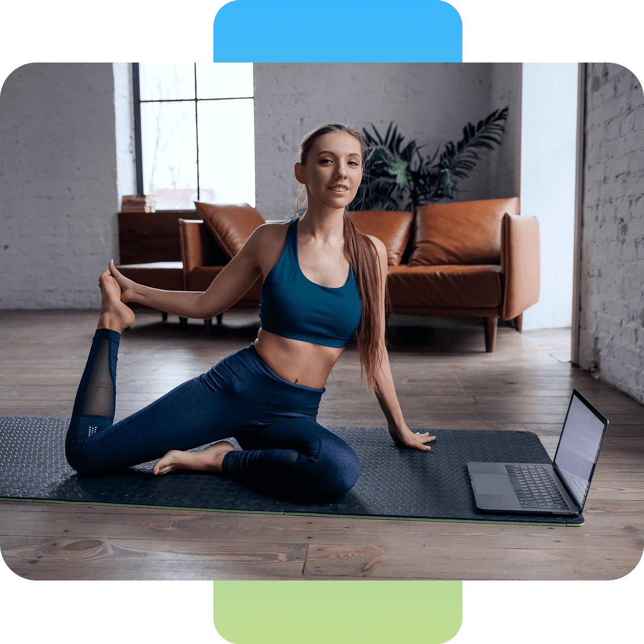 Woman doing yoga indoors with a laptop nearby.